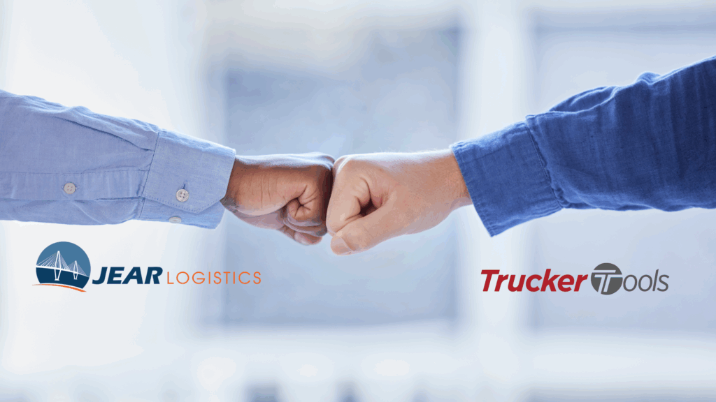 Two people in blue shirts fist-bumping, with the JEAR Logistics logo on the left and the Trucker Tools logo on the right, symbolizing partnership or collaboration.