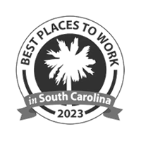 A circular badge with a palmetto tree in the center. Text reads Best Places to Work in South Carolina 2023 with a ribbon across the bottom.